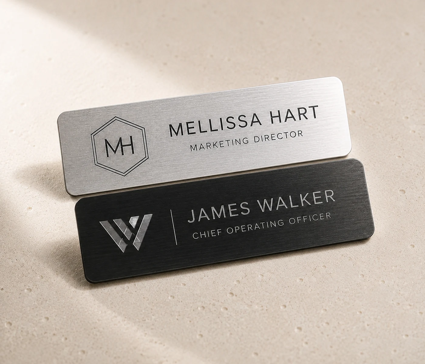 Silver Mellissa Hart and black James Walker engraved staff name badges